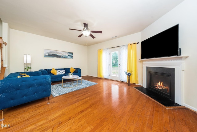 1017 Frank Page Dr, Cary, NC 27511 - living area with wood finished floors, a glass covered fireplace, and a ceiling fan