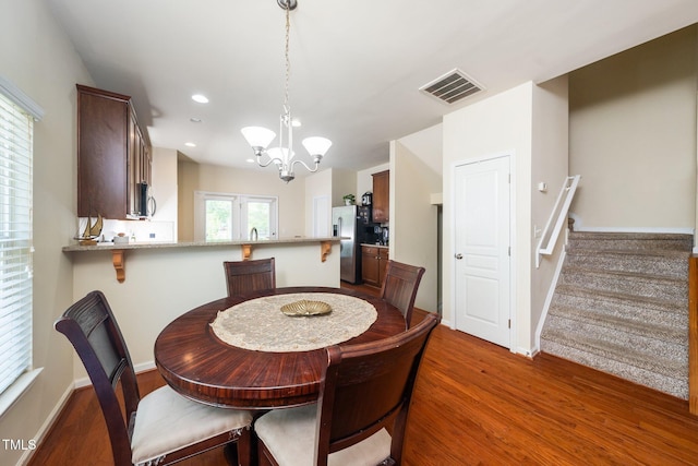 1017 Frank Page Dr, Cary, NC 27511 - dining space featuring a chandelier, stairway, dark wood finished floors, recessed lighting, and baseboards