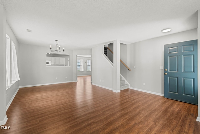 518 Clearfield Dr, Durham, NC 27703 - unfurnished living room featuring a chandelier, dark wood-style floors, and stairs