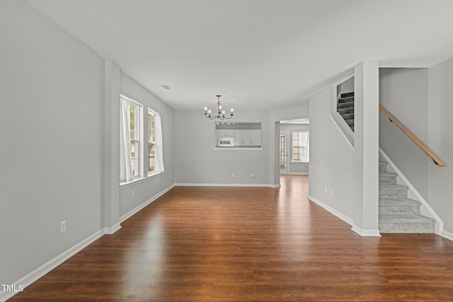518 Clearfield Dr, Durham, NC 27703 - unfurnished living room featuring a chandelier, healthy amount of natural light, and wood finished floors