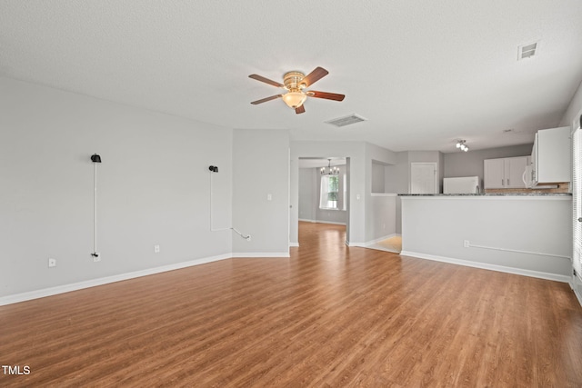 518 Clearfield Dr, Durham, NC 27703 - unfurnished living room featuring ceiling fan, light wood-type flooring, and a textured ceiling