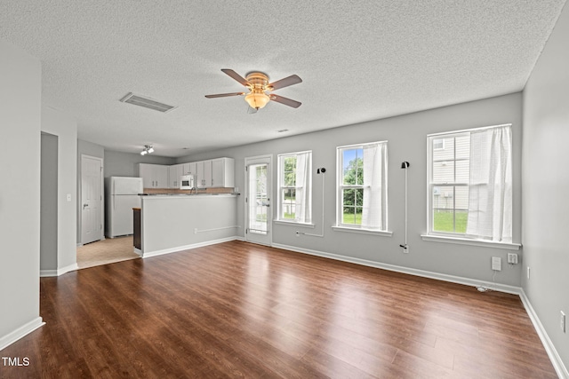 518 Clearfield Dr, Durham, NC 27703 - unfurnished living room with wood finished floors, a ceiling fan, and a textured ceiling