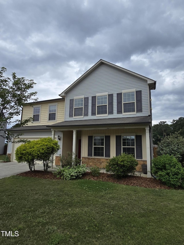 2511 Dalmahoy Ln, Fuquay Varina, NC 27526 - view of front of home with a front yard, concrete driveway, stone siding, and a garage