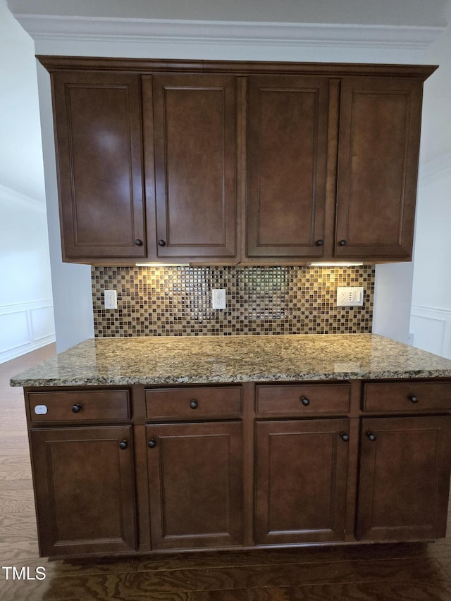 2511 Dalmahoy Ln, Fuquay Varina, NC 27526 - kitchen with tasteful backsplash, light stone countertops, dark brown cabinetry, ornamental molding, and dark wood-type flooring