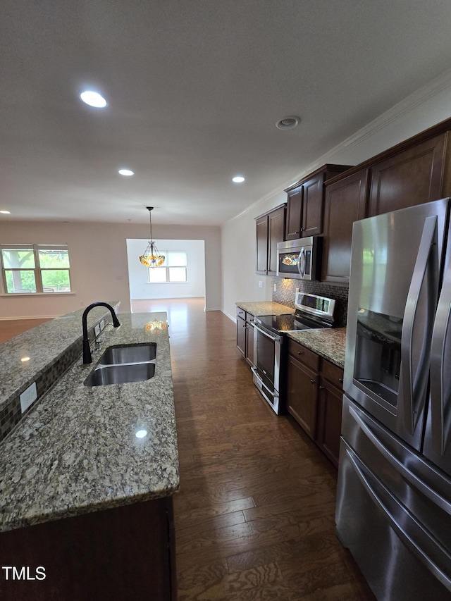 2511 Dalmahoy Ln, Fuquay Varina, NC 27526 - kitchen featuring stainless steel appliances, a sink, backsplash, dark brown cabinetry, and dark wood-type flooring