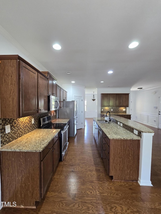 2511 Dalmahoy Ln, Fuquay Varina, NC 27526 - kitchen with stainless steel appliances, a sink, tasteful backsplash, dark wood finished floors, and light stone countertops