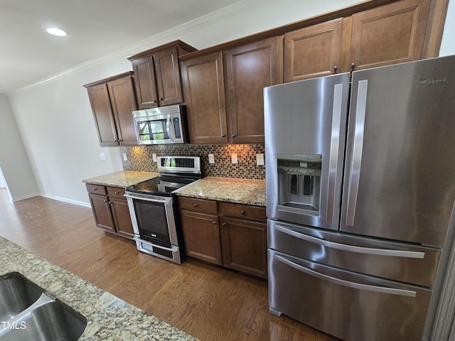 2511 Dalmahoy Ln, Fuquay Varina, NC 27526 - kitchen with stainless steel appliances, dark wood-type flooring, decorative backsplash, baseboards, and crown molding