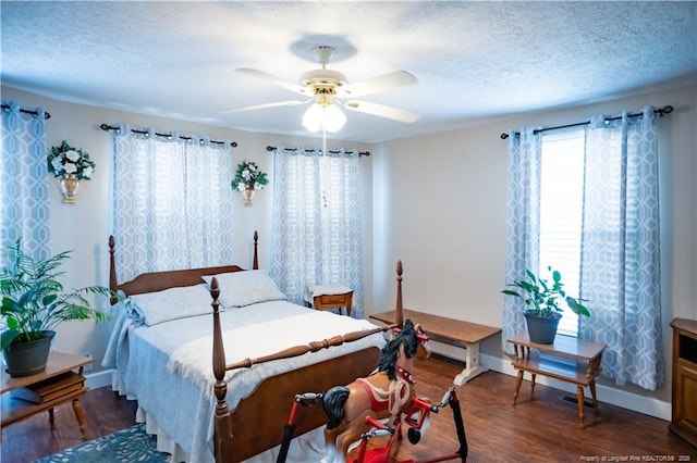 208 W Thompson St E, Fairmont, NC 28340 - bedroom featuring dark wood-style floors, a textured ceiling, baseboards, and a ceiling fan
