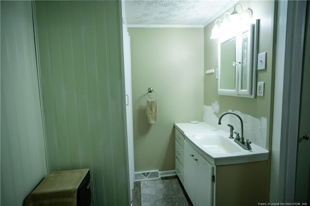 208 W Thompson St E, Fairmont, NC 28340 - bathroom featuring vanity, ornamental molding, a textured ceiling, and baseboards