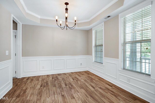 112 Briarfield Dr, Apex, NC 27502 - unfurnished room with a chandelier, plenty of natural light, a wainscoted wall, wood finished floors, and ornamental molding