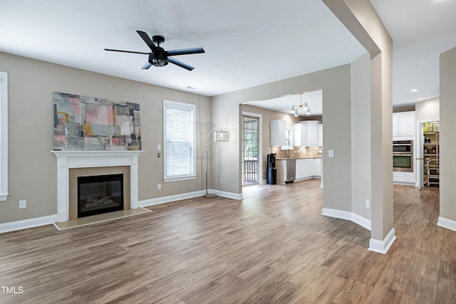 112 Briarfield Dr, Apex, NC 27502 - unfurnished living room featuring a high end fireplace, light wood-style flooring, a ceiling fan, and recessed lighting