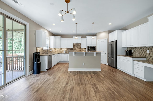 112 Briarfield Dr, Apex, NC 27502 - kitchen featuring appliances with stainless steel finishes, decorative backsplash, wood finished floors, white cabinets, and recessed lighting