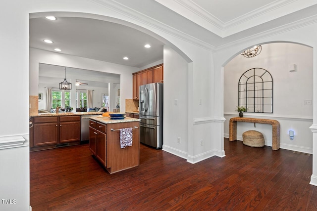 1612 Old Bramble Ln, Fuquay Varina, NC 27526 - kitchen featuring stainless steel appliances, dark wood-style flooring, light stone countertops, arched walkways, and a peninsula