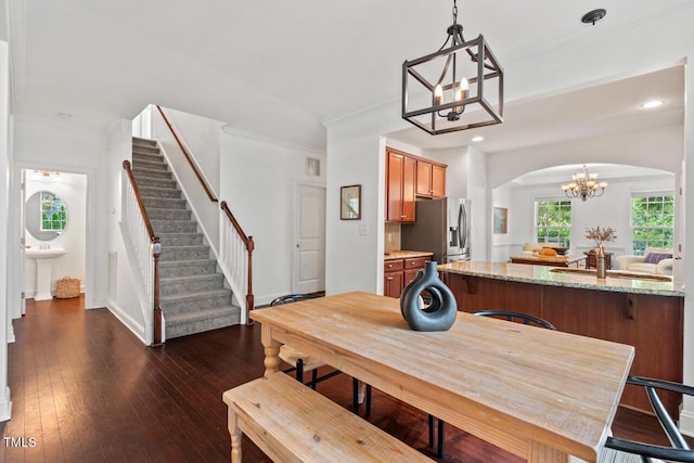 1612 Old Bramble Ln, Fuquay Varina, NC 27526 - dining area featuring a chandelier, arched walkways, stairs, dark wood-style floors, and recessed lighting