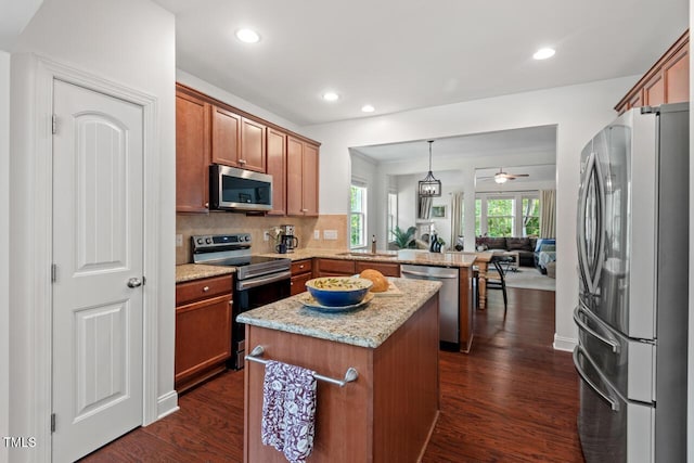 1612 Old Bramble Ln, Fuquay Varina, NC 27526 - kitchen with stainless steel appliances, a peninsula, open floor plan, dark wood-style flooring, and recessed lighting