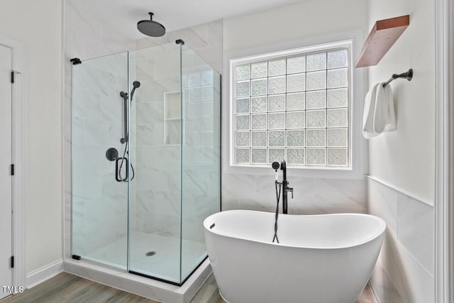 1612 Old Bramble Ln, Fuquay Varina, NC 27526 - bathroom featuring a shower stall, a freestanding bath, tile walls, and wood finished floors