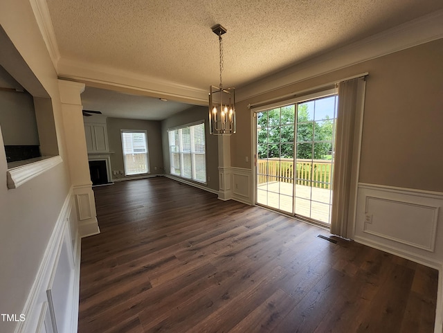 4903 Bridgewood Dr, Durham, NC 27713 - unfurnished dining area featuring a textured ceiling, a chandelier, a decorative wall, healthy amount of natural light, and dark wood-type flooring