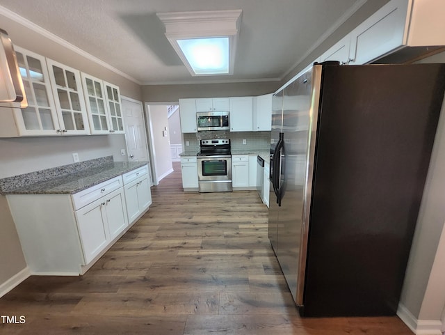 4903 Bridgewood Dr, Durham, NC 27713 - kitchen featuring stainless steel appliances, ornamental molding, wood finished floors, white cabinets, and light stone countertops