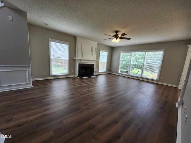 4903 Bridgewood Dr, Durham, NC 27713 - unfurnished living room with ceiling fan, a fireplace, a textured ceiling, dark wood-type flooring, and baseboards