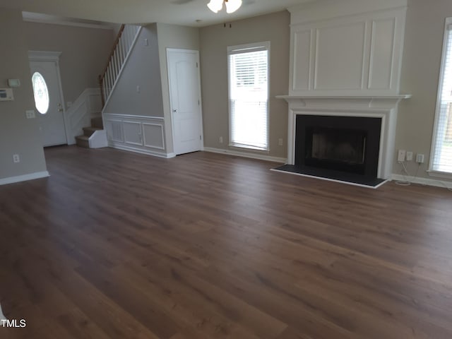 4903 Bridgewood Dr, Durham, NC 27713 - unfurnished living room featuring dark wood-style flooring, stairway, a fireplace with raised hearth, a ceiling fan, and baseboards