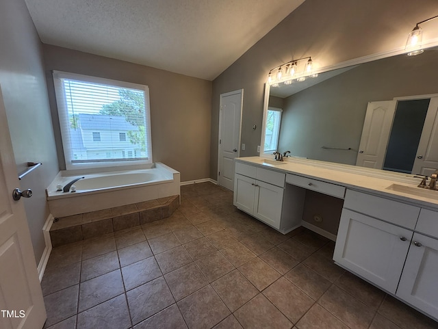 4903 Bridgewood Dr, Durham, NC 27713 - bathroom with vaulted ceiling, double vanity, a garden tub, tile patterned floors, and a textured ceiling