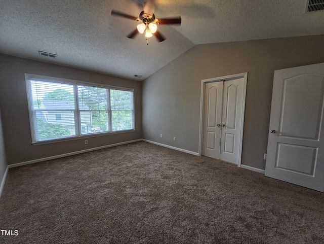 4903 Bridgewood Dr, Durham, NC 27713 - unfurnished bedroom featuring a textured ceiling, vaulted ceiling, baseboards, a closet, and carpet