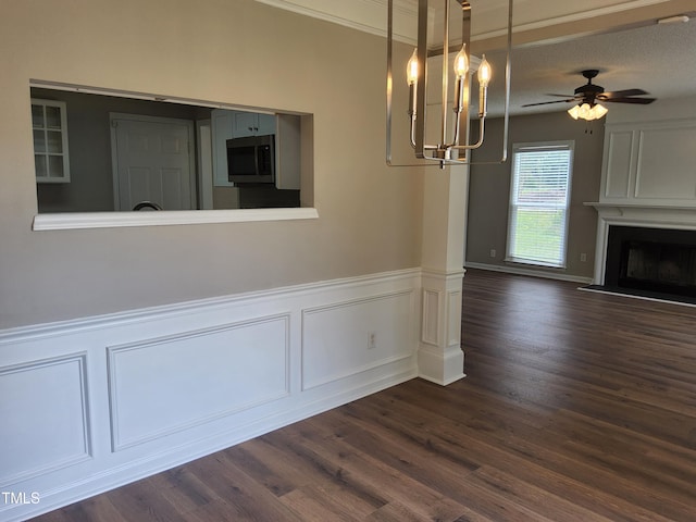 4903 Bridgewood Dr, Durham, NC 27713 - unfurnished dining area with dark wood-type flooring, a chandelier, a fireplace with raised hearth, wainscoting, and a ceiling fan