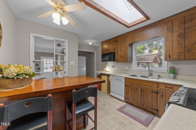 1040 Ivy Ln, Cary, NC 27511 - kitchen featuring black appliances, a skylight, a ceiling fan, and wooden counters