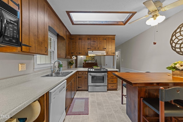 1040 Ivy Ln, Cary, NC 27511 - kitchen featuring stainless steel range with electric cooktop, dishwasher, under cabinet range hood, black microwave, and a skylight