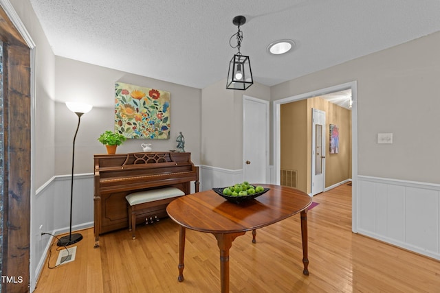 1040 Ivy Ln, Cary, NC 27511 - sitting room with light wood-style flooring, a wainscoted wall, and a textured ceiling