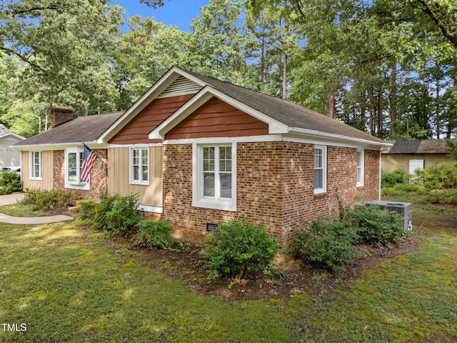 1040 Ivy Ln, Cary, NC 27511 - view of side of property featuring a chimney, a lawn, board and batten siding, and brick siding