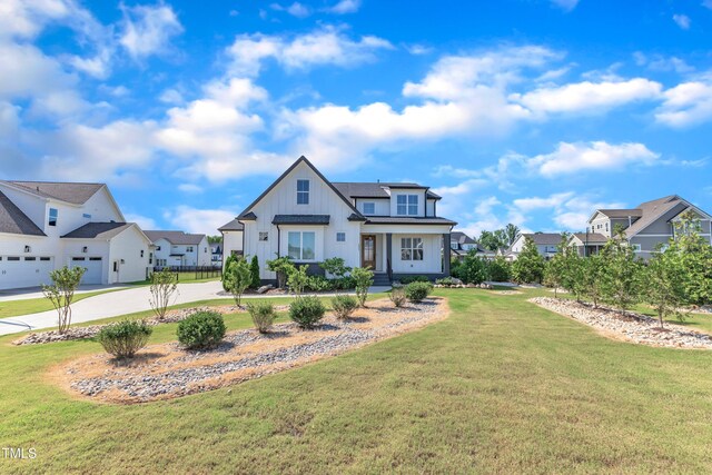 121 Nate Ct, Wake Forest, NC 27587 - modern farmhouse with board and batten siding, a residential view, concrete driveway, a garage, and a front lawn