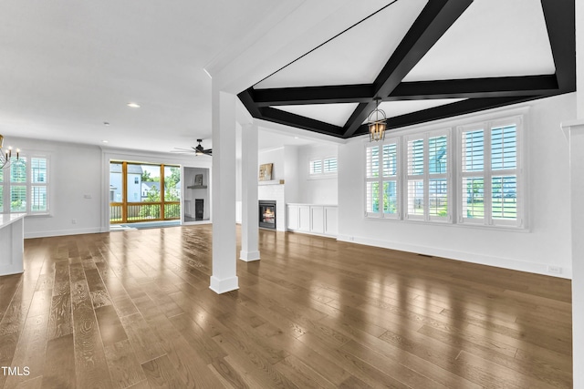121 Nate Ct, Wake Forest, NC 27587 - unfurnished living room featuring a chandelier, a glass covered fireplace, baseboards, ceiling fan, and beamed ceiling