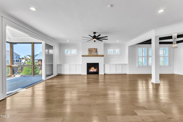121 Nate Ct, Wake Forest, NC 27587 - unfurnished living room with a ceiling fan, wood-type flooring, recessed lighting, a warm lit fireplace, and baseboards