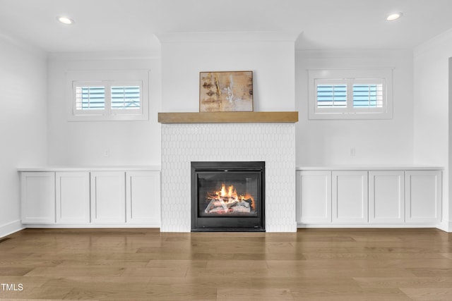 121 Nate Ct, Wake Forest, NC 27587 - detailed view of a glass covered fireplace, wood finished floors, recessed lighting, and ornamental molding