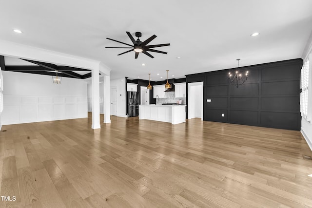121 Nate Ct, Wake Forest, NC 27587 - unfurnished living room with a decorative wall, a chandelier, light wood finished floors, ceiling fan, and a sink