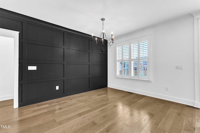121 Nate Ct, Wake Forest, NC 27587 - unfurnished dining area with a decorative wall, a chandelier, light wood-style flooring, and baseboards