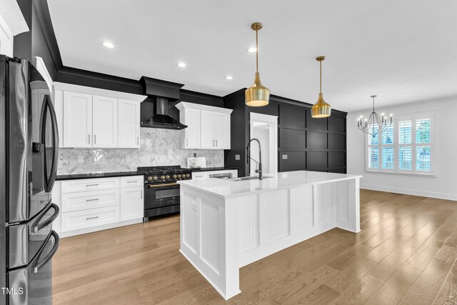 121 Nate Ct, Wake Forest, NC 27587 - kitchen featuring stainless steel appliances, wall chimney exhaust hood, a sink, backsplash, and a chandelier
