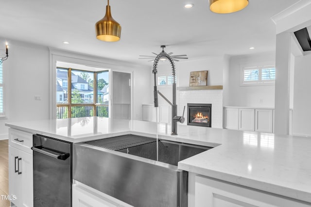 121 Nate Ct, Wake Forest, NC 27587 - kitchen featuring a sink, a brick fireplace, light stone counters, white cabinets, and recessed lighting