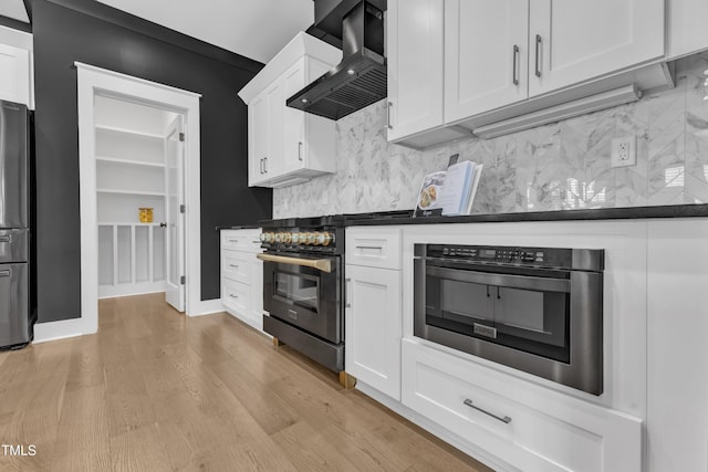 121 Nate Ct, Wake Forest, NC 27587 - kitchen with wall chimney exhaust hood, high end stainless steel range oven, white cabinets, light wood finished floors, and dark countertops