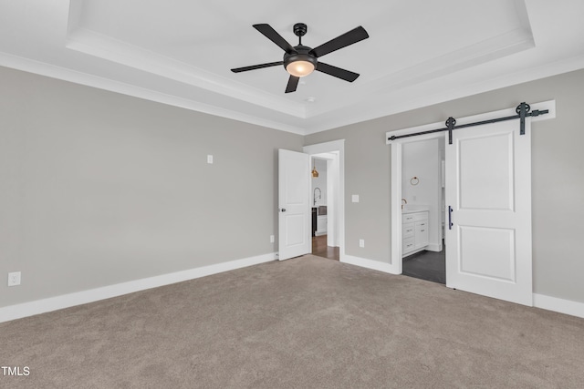 121 Nate Ct, Wake Forest, NC 27587 - unfurnished bedroom with a raised ceiling, a barn door, dark colored carpet, ornamental molding, and baseboards