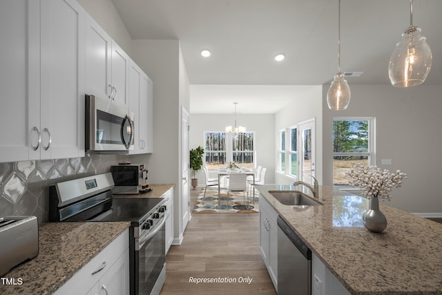 455 Beacon Hill Rd # 28, Lillington, NC 27546 - kitchen with stainless steel appliances, a sink, light wood finished floors, decorative backsplash, and a chandelier