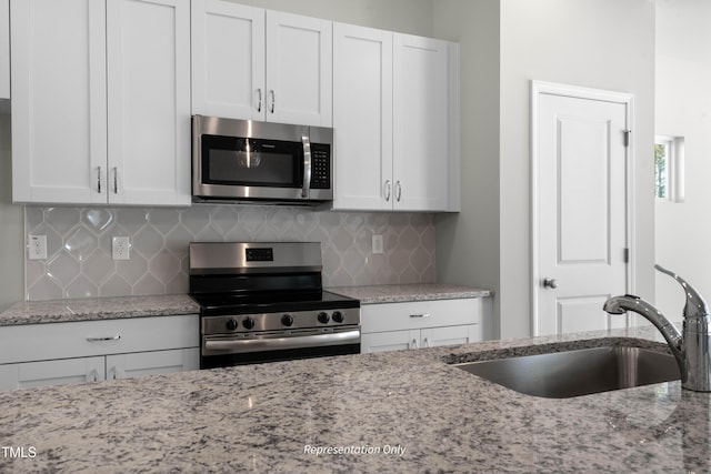 455 Beacon Hill Rd # 28, Lillington, NC 27546 - kitchen featuring stainless steel appliances, a sink, decorative backsplash, and light stone countertops