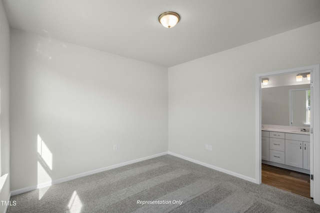 455 Beacon Hill Rd # 28, Lillington, NC 27546 - unfurnished bedroom featuring carpet flooring, a sink, baseboards, and connected bathroom