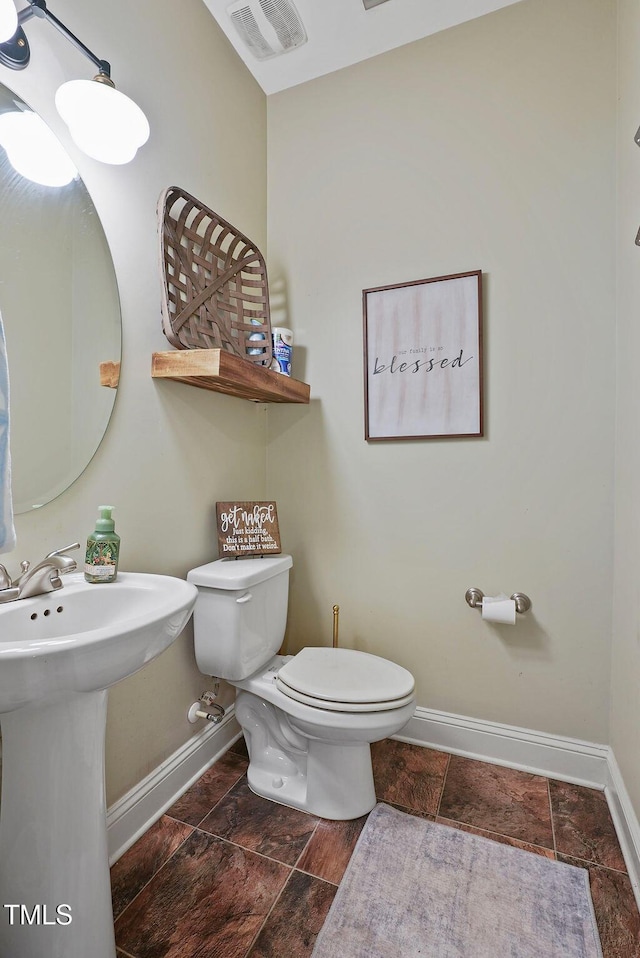 15 Scuppernong Ln, Lillington, NC 27546 - half bathroom featuring baseboards, toilet, and stone finish floors
