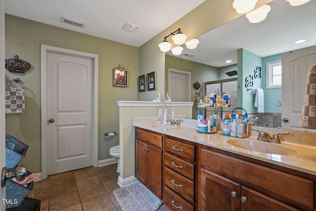 15 Scuppernong Ln, Lillington, NC 27546 - bathroom with toilet, double vanity, tile patterned flooring, a shower stall, and baseboards