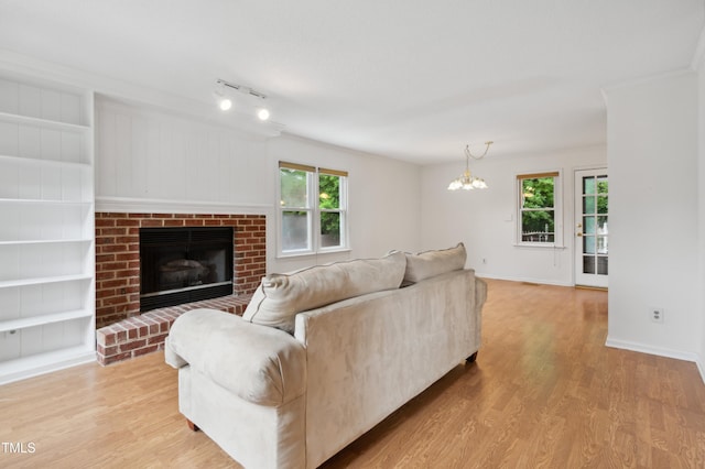 3405 E Jameson Rd, Raleigh, NC 27604 - living room featuring light wood-type flooring, plenty of natural light, a chandelier, and ornamental molding