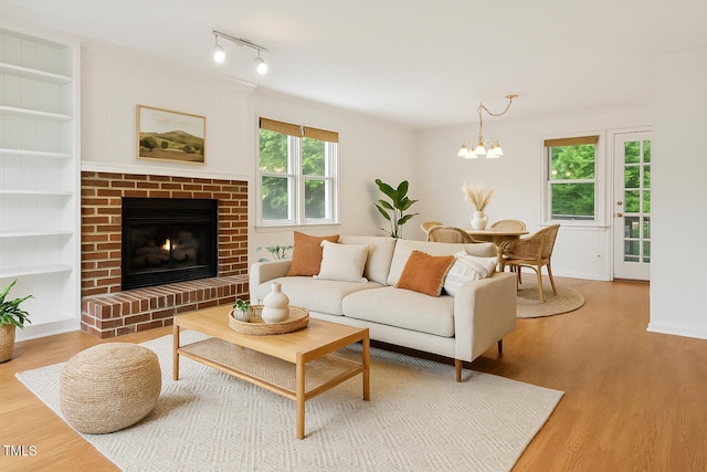 3405 E Jameson Rd, Raleigh, NC 27604 - living room with a chandelier, wood finished floors, a brick fireplace, and built in features
