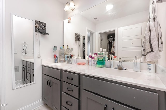 18 Hunter Fox Trl, Angier, NC 27501 - bathroom with double vanity, a walk in closet, and baseboards