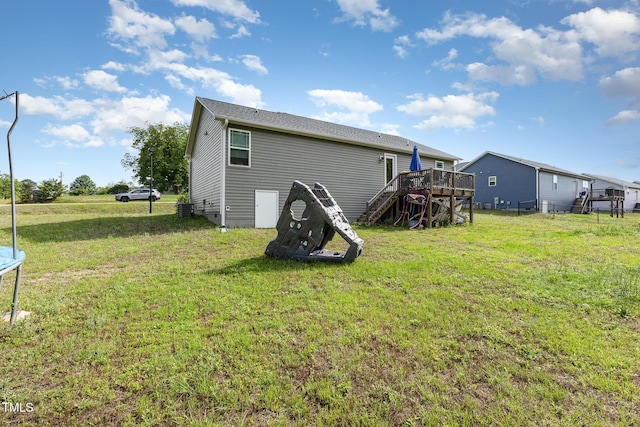 18 Hunter Fox Trl, Angier, NC 27501 - rear view of property featuring a deck, a trampoline, a lawn, central air condition unit, and stairway